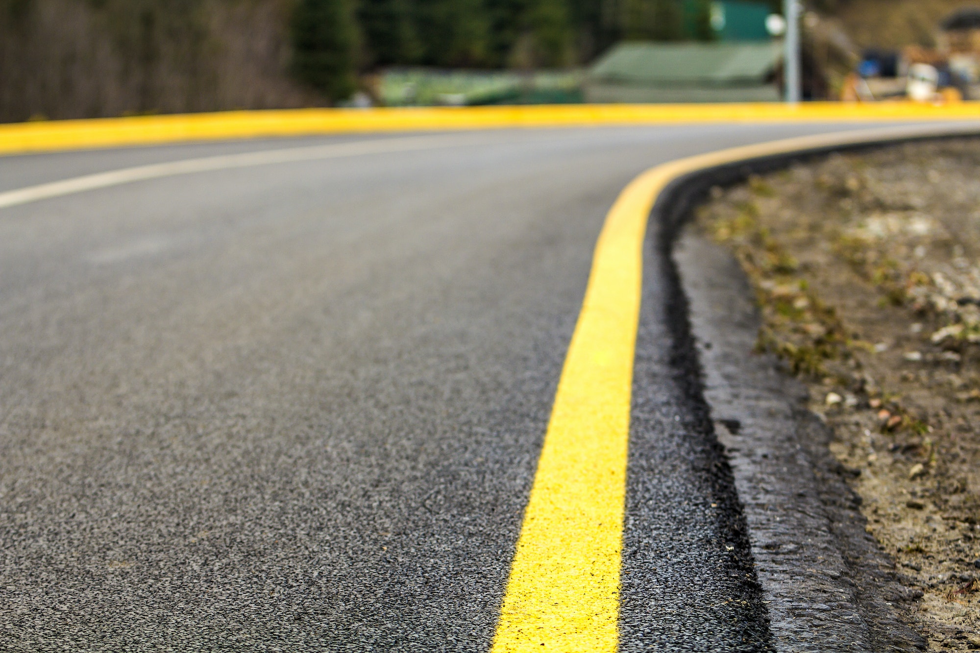 Perspective of asphalt road with yellow line on it